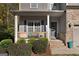 Charming front porch with decorative columns, seating, and landscaped bushes, perfect for relaxing outdoors at 1412 Short Ct, Mcdonough, GA 30252
