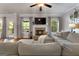 Cozy living room with a brick fireplace, mounted TV, plush sectional, and views of the backyard at 1412 Short Ct, Mcdonough, GA 30252