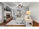 Comfortable living room featuring a brick fireplace, large sectional sofa, and modern ceiling fan at 1412 Short Ct, Mcdonough, GA 30252