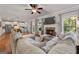 Open-concept living room showcasing a brick fireplace, hardwood floors, and seamless flow to the kitchen at 1412 Short Ct, Mcdonough, GA 30252