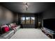 Dark room with carpet, brown leather reclining sofa, and large windows at 1690 Geranium Ln, Cumming, GA 30040
