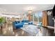 Bright living room with a blue sectional couch, dark wood floors, and modern chandelier at 1690 Geranium Ln, Cumming, GA 30040