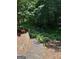 The secluded backyard features a stone patio and stairs to a wooden area at 245 River Laurel Way, Woodstock, GA 30188