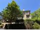 The backyard view of the home features a large tree and a retaining wall at 245 River Laurel Way, Woodstock, GA 30188