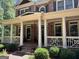 Inviting front porch with classic columns and detailed railings on a well-kept brick home at 245 River Laurel Way, Woodstock, GA 30188
