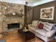 The comfortable living room boasts a stone fireplace and hardwood floors at 245 River Laurel Way, Woodstock, GA 30188