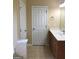 Bright bathroom featuring a single sink vanity, toilet, and a white paneled door at 436 Abbey Pl, Villa Rica, GA 30180