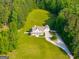 Aerial view of a large white farmhouse with expansive green lawns and surrounding trees at 692 Brooks Woolsey Rd, Brooks, GA 30205