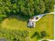 Overhead shot showcasing a home nestled amongst green grass and bordered by a line of trees at 692 Brooks Woolsey Rd, Brooks, GA 30205