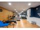 Basement gym with mirrored wall, various exercise machines, and wood-look floors at 692 Brooks Woolsey Rd, Brooks, GA 30205