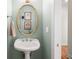 Stylish powder room with pedestal sink, gold mirror, and elegant wall decor at 692 Brooks Woolsey Rd, Brooks, GA 30205