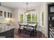 Sunny dining area with large windows, a rustic table, and views of the landscaped backyard at 692 Brooks Woolsey Rd, Brooks, GA 30205