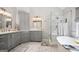 Bright bathroom with a free standing tub, a glass enclosed shower, and and sinks at 960 Pebblestone Ct, Alpharetta, GA 30009
