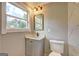 Bathroom features a modern vanity, black faucet, and toilet with tiled walls and a bright window view at 375 Foster Dr, Mcdonough, GA 30253