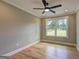Sunlit bedroom with hardwood floors, neutral walls, a ceiling fan, and large window for natural light at 375 Foster Dr, Mcdonough, GA 30253