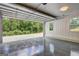 Spacious garage featuring epoxy floors, bright lighting, with a large window and open door with wooded view at 375 Foster Dr, Mcdonough, GA 30253