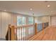 Upstairs hallway with hardwood floors, natural lighting, and wooden and iron railing at 375 Foster Dr, Mcdonough, GA 30253