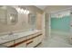 Bright bathroom with double sink vanity, decorative mirrors, and access to a walk-in closet and bedroom at 157 Rockspray Rdg, Peachtree City, GA 30269