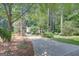 Long driveway leading to a well-maintained home with mature trees and landscaping at 157 Rockspray Rdg, Peachtree City, GA 30269
