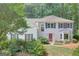 Charming two-story home with a red door and landscaped yard and a lush green tree in the front at 157 Rockspray Rdg, Peachtree City, GA 30269