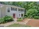 Inviting two-story home featuring mature landscaping and a red door at 157 Rockspray Rdg, Peachtree City, GA 30269