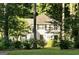 Inviting two-story home with black shutters nestled among mature trees, exuding classic charm and tranquility at 157 Rockspray Rdg, Peachtree City, GA 30269
