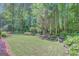 Lush, well-maintained backyard with manicured lawn and garden beds surrounded by trees at 157 Rockspray Rdg, Peachtree City, GA 30269