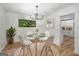 Dining area with modern table, white chairs, and view of a white modern kitchen at 7455 Dover Ct, Riverdale, GA 30274