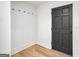 Bright entryway with built-in storage, hooks, wood-look flooring, and a black front door at 7455 Dover Ct, Riverdale, GA 30274