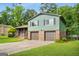 Split level house with a brick facade, two car garage, and mature trees at 7455 Dover Ct, Riverdale, GA 30274