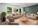 Staged living room with neutral furniture, modern accent wall, and natural light at 7455 Dover Ct, Riverdale, GA 30274