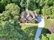 Aerial shot of a brick home surrounded by lush trees and foliage on a well manicured lawn at 1315 Crane Ct, Mcdonough, GA 30252