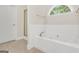 Bright bathroom featuring a soaking tub, shower, and a decorative window for added natural light at 1315 Crane Ct, Mcdonough, GA 30252
