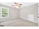 Spacious bedroom featuring a ceiling fan, closet, and natural light from a large window at 1315 Crane Ct, Mcdonough, GA 30252