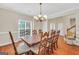 Bright dining room with large window, chandelier, and wood table set at 1315 Crane Ct, Mcdonough, GA 30252