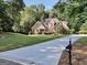 A long concrete driveway leads to this well-maintained brick home, with mature trees and inviting curb appeal at 1315 Crane Ct, Mcdonough, GA 30252