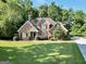 Charming brick home with a lush green lawn and mature trees, offering a serene and inviting curb appeal at 1315 Crane Ct, Mcdonough, GA 30252
