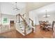View of the living spaces featuring wood floors, staircase, dining room, and a fireplace, creating an open floor plan at 1315 Crane Ct, Mcdonough, GA 30252