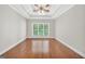 Main bedroom with tray ceiling, ceiling fan, hardwood floors, and natural light at 1315 Crane Ct, Mcdonough, GA 30252