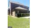 Brick home backyard featuring tidy lawn, storage bins, and a serene, private outdoor space at 1869 Schofield Dr, Hampton, GA 30228