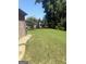The backyard shows lush green grass, a brick home, and privacy landscaping at 1869 Schofield Dr, Hampton, GA 30228