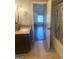 A neutral-toned bathroom featuring a vanity with a granite countertop, a decorative mirror, and a view into the bedroom at 1869 Schofield Dr, Hampton, GA 30228