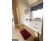 Bright bathroom features a soaking tub with decor, large tile floors, and a window with decorative curtains at 1869 Schofield Dr, Hampton, GA 30228