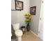 Bathroom with beige tile floor, toilet, decorative flowers in a vase, and framed pictures on the wall at 1869 Schofield Dr, Hampton, GA 30228