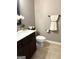 Half bathroom featuring dark wood cabinetry, neutral paint, and a decorative orchid at 1869 Schofield Dr, Hampton, GA 30228