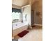 Bright bathroom features a soaking tub, decorative candles, large tile floors, and a glass shower at 1869 Schofield Dr, Hampton, GA 30228