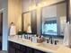 Bathroom with double sink vanity, decorative mirrors, updated faucets, and a soaking tub in the background at 1869 Schofield Dr, Hampton, GA 30228
