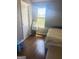 Bedroom featuring a bed, hardwood flooring, a window with blinds, and a nightstand with a lamp at 1869 Schofield Dr, Hampton, GA 30228