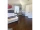 A bright bedroom shows hardwood floors, white bench, accent wall art, and exercise equipment at 1869 Schofield Dr, Hampton, GA 30228