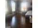 A bright bedroom exhibits hardwood floors, stylish decor, and light-filled windows at 1869 Schofield Dr, Hampton, GA 30228